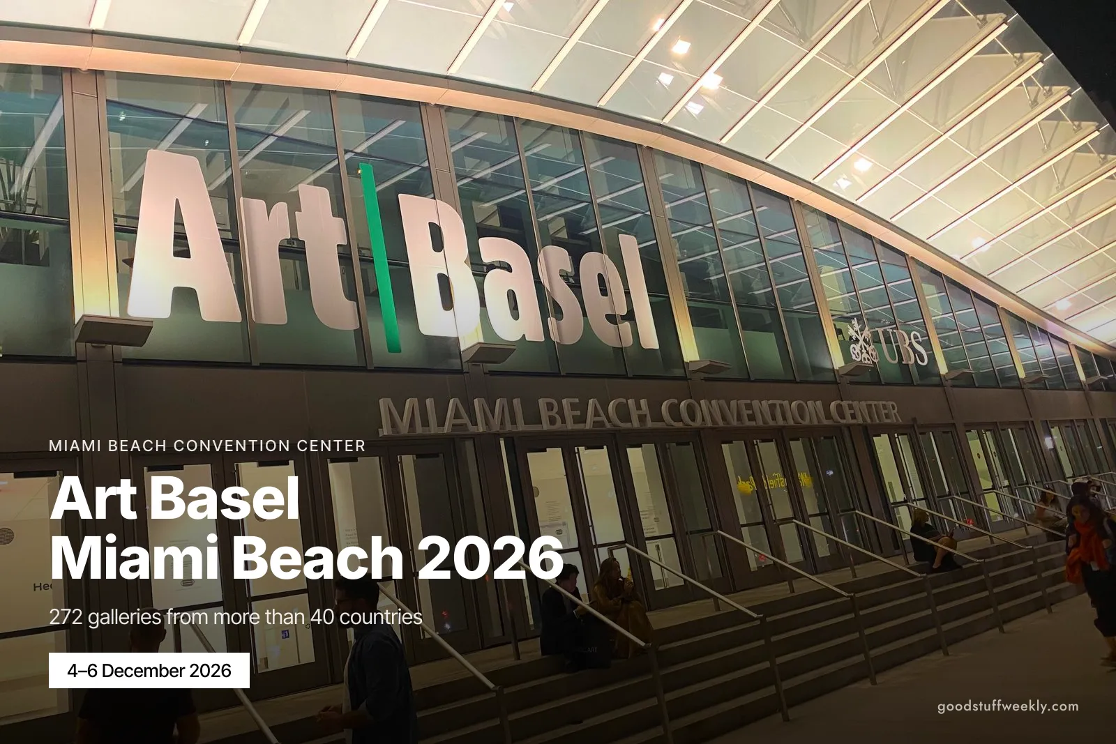 The Art Basel sign lit up on the facade of the Miami Beach Convention Center at night