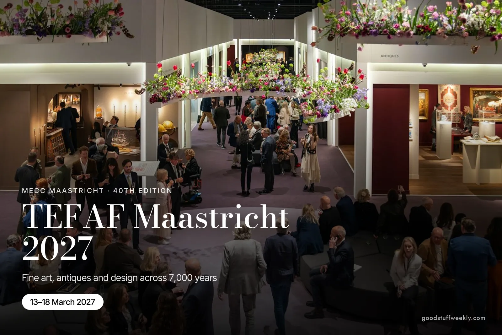 Visitors in an aisle hung with flower arrangements between dealers' stands at TEFAF Maastricht
